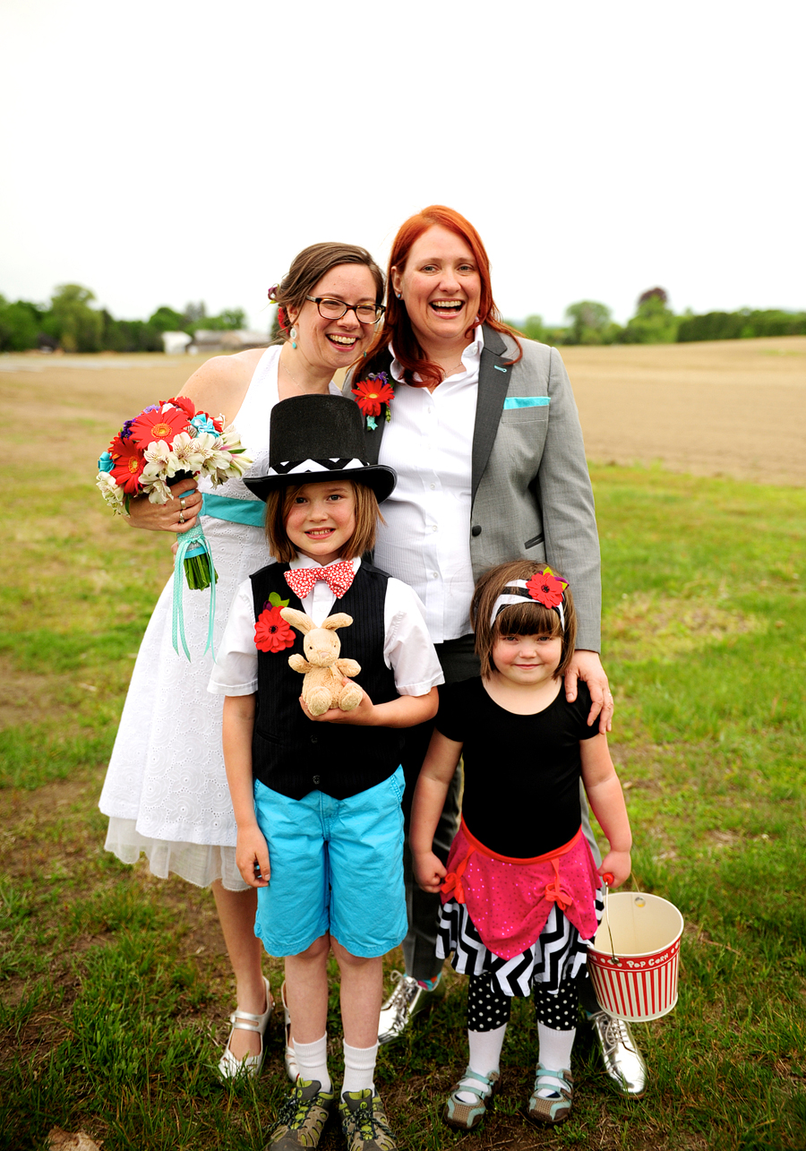 brides posing with flower girl and ring bearer