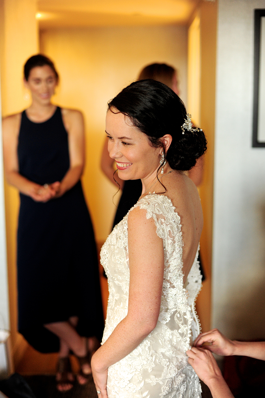 bride having her dress buttoned