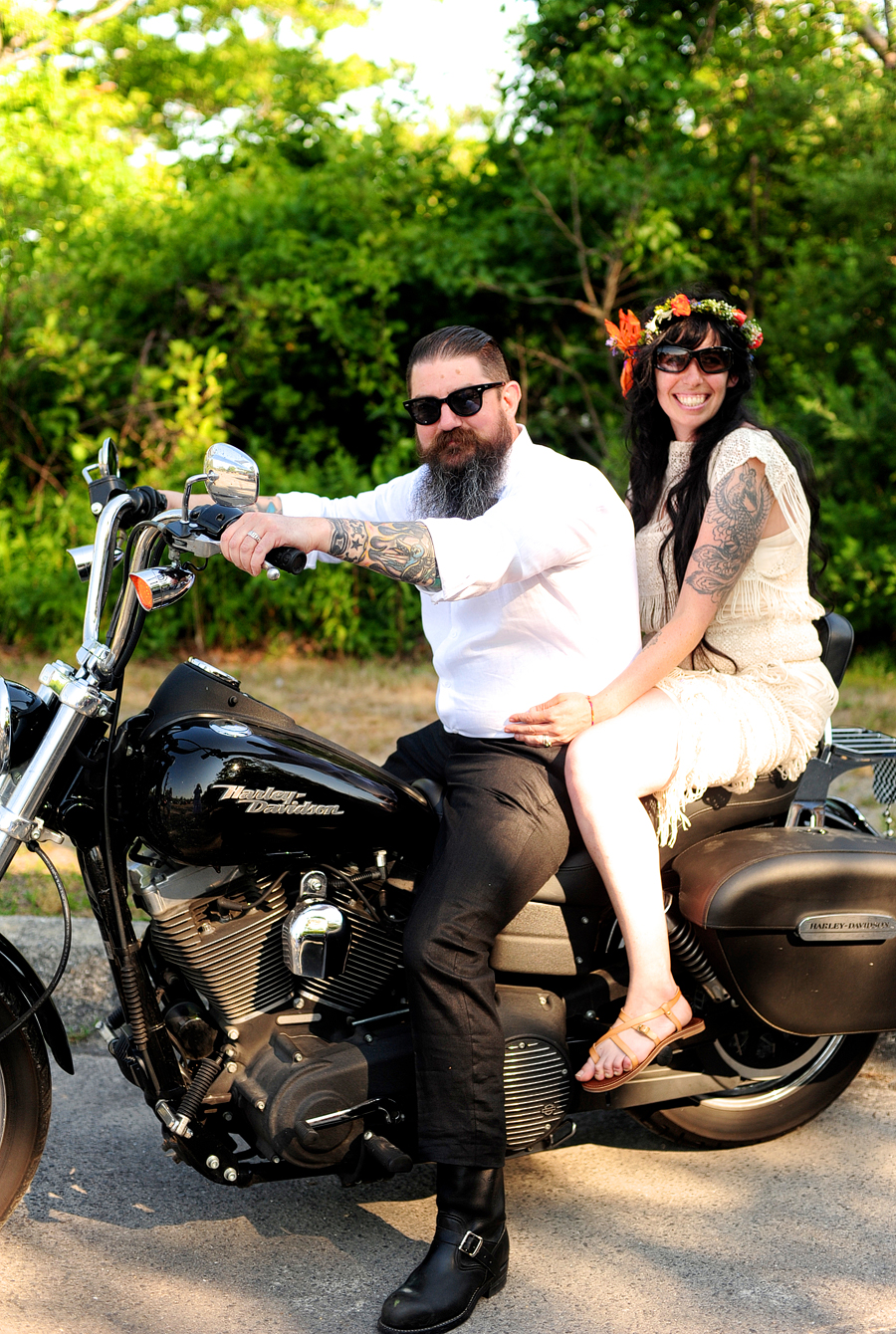 couple riding away from wedding ceremony on a motorcycle in maine