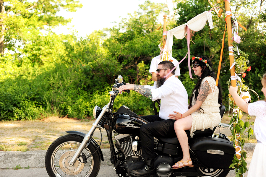 indie, tattooed couple leaving wedding ceremony on a motorcycle