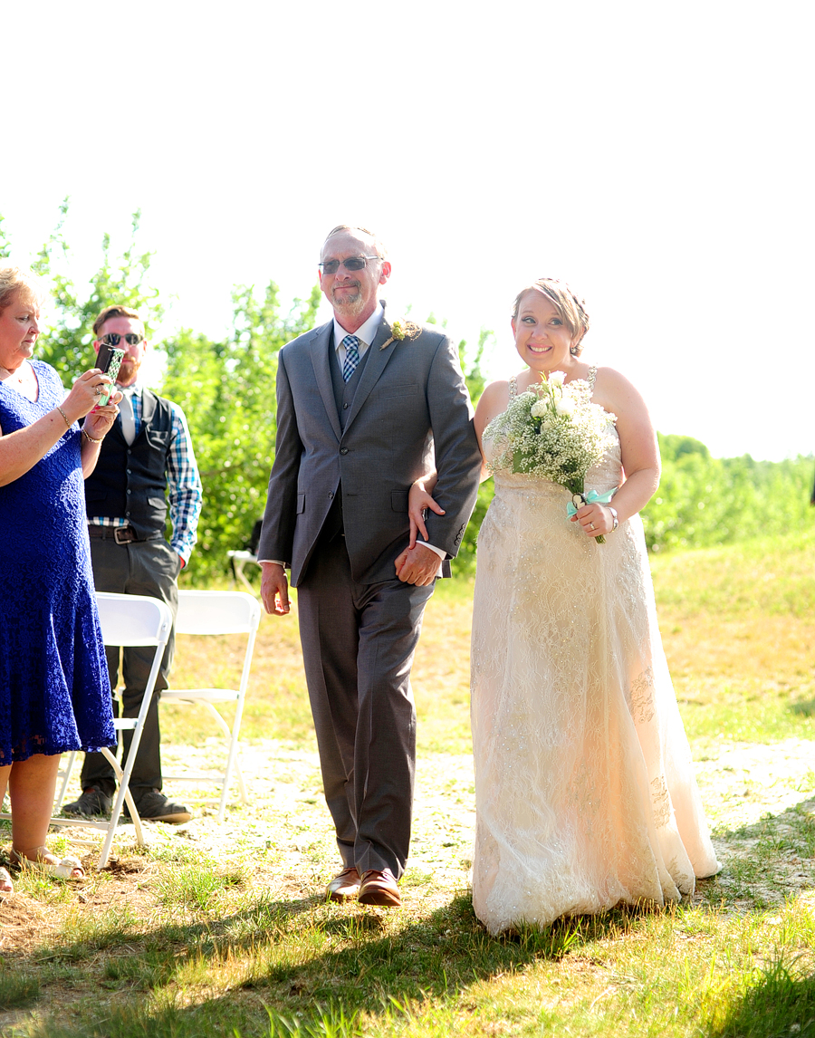 bride walking down an outdoor aisle with her dad