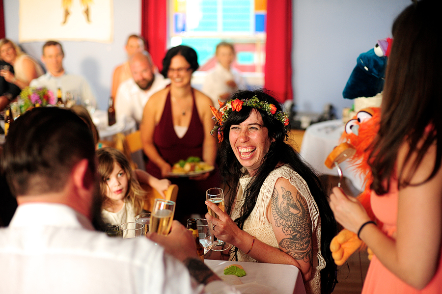tattooed bride with flower crown laughing at a wedding toast in portland, maine