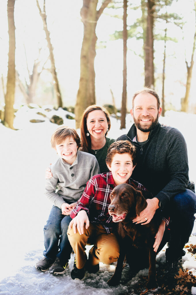 a smiling family of 4 with their dog