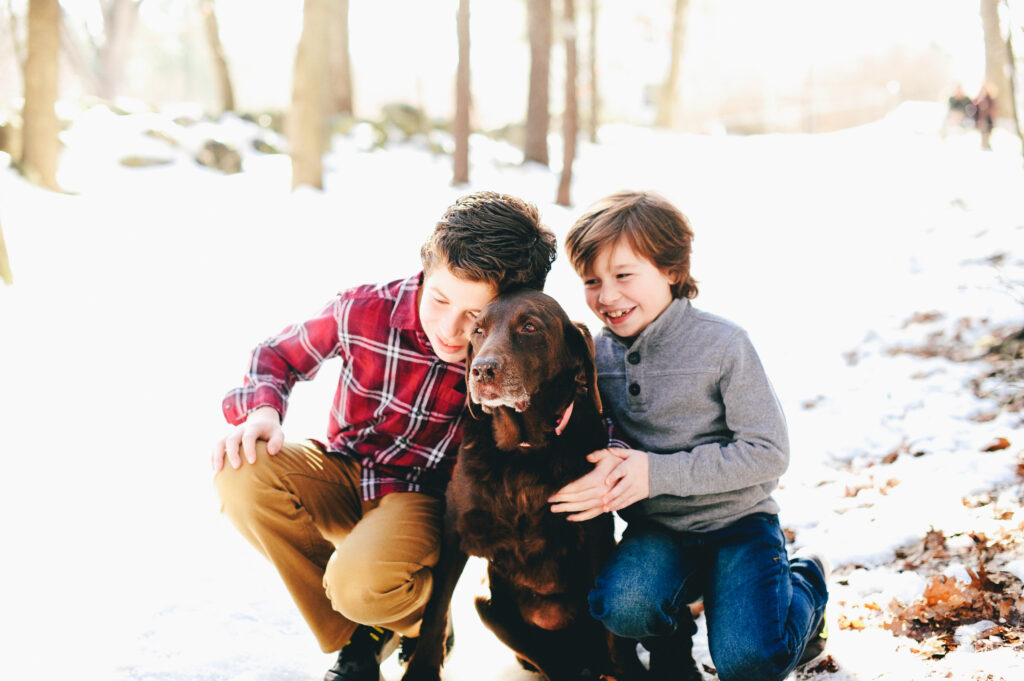 two brothers hug their family dog