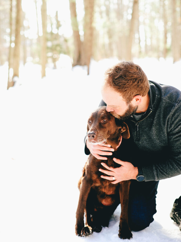 a man kisses his brown dog on the head